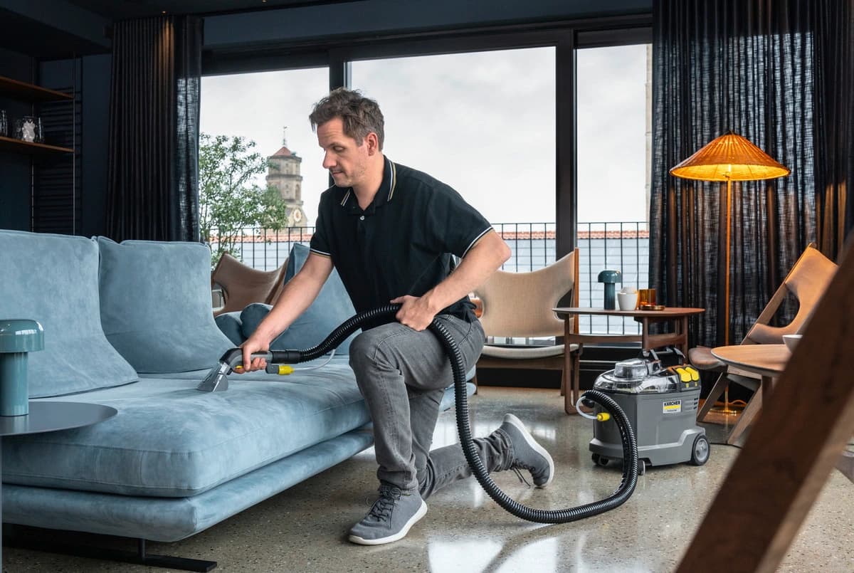 Man maakt een bank schoon met Karcher Puzzi 8/1